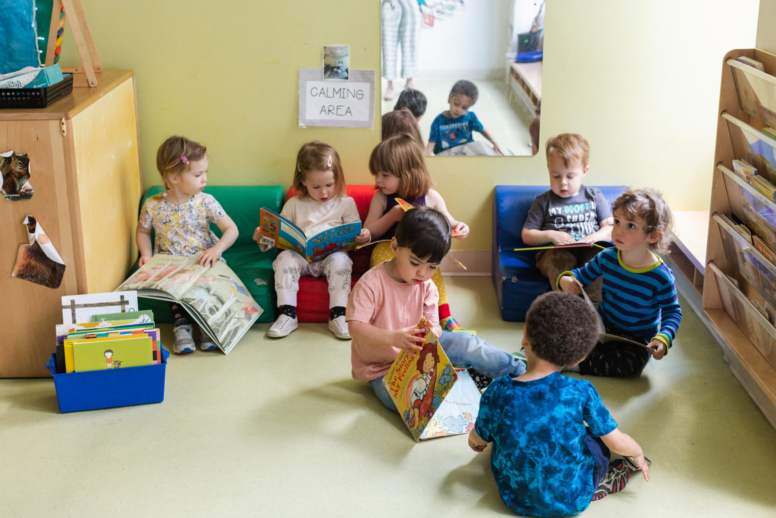 A group of children sitting in the floor reading books.