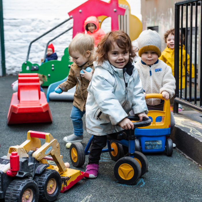A group of children playing with toys on the ground.