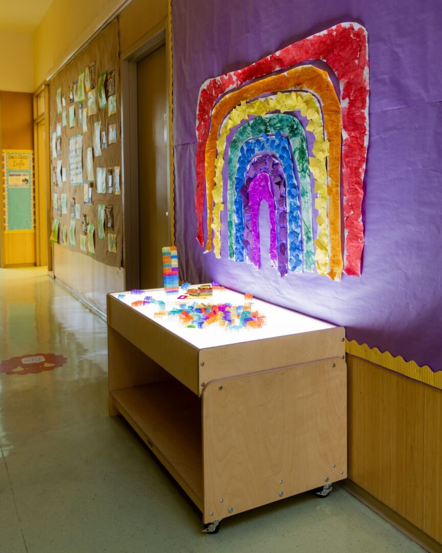 A colorful rainbow mural in the hallway of a school.