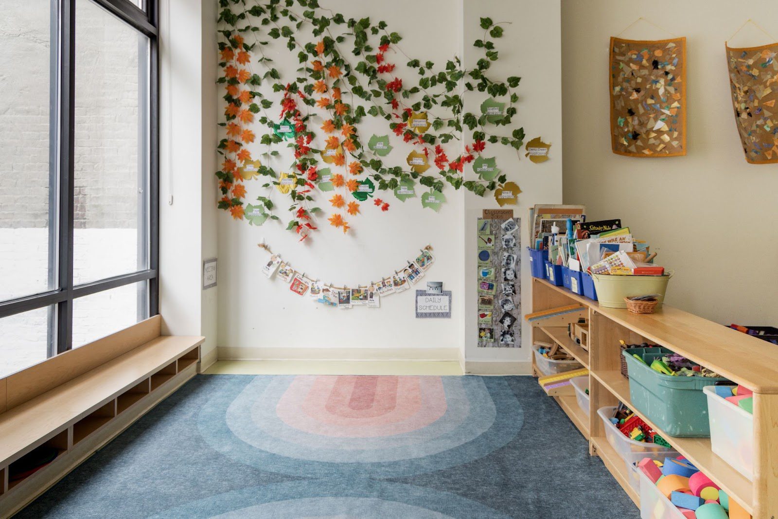 A room with shelves and a wall of leaves.