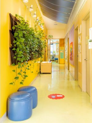 A hallway with yellow walls and blue furniture.