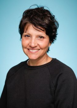 A woman with short hair smiles for the camera.