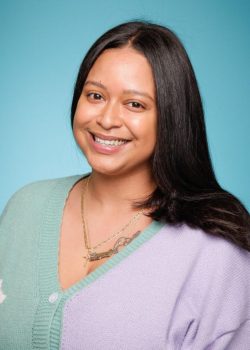 A woman with long black hair smiles for the camera.