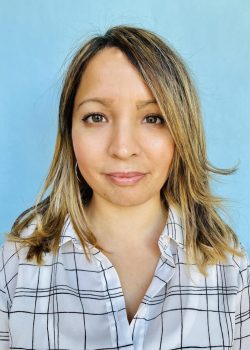 A woman with long hair wearing a plaid shirt.