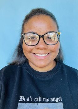 A woman with glasses smiling for the camera.